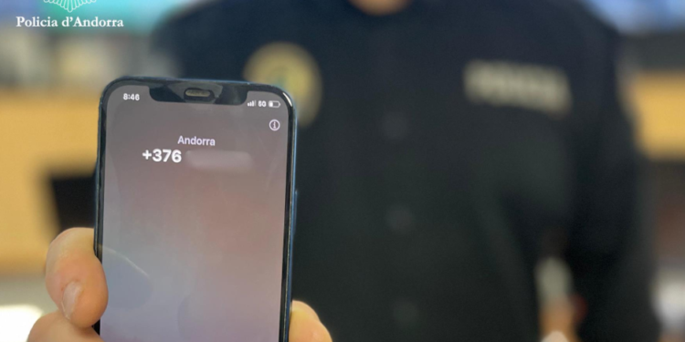 Agent de policia amb un telèfon a la mà.
