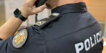 Un policia rebent una trucada d'avís.