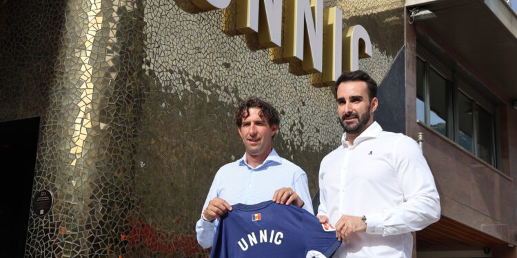 El director esportiu de l'FC Andorra, Jaume Nogués, i el director general del centre d'oci Unnic, José Fulgencio, amb la samarreta que ofereix el club a l'entitat pel conveni. Foto: ANA.