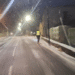 Un jove circulant per una carretera d'Andorra amb patinet elèctric mentre neva de nit.