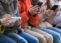 Un grup de nens fan servir el mòbil i les xarxes socials al carrer (Foto: Xarxes).