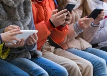 Un grup de nens fan servir el mòbil i les xarxes socials al carrer (Foto: Xarxes).