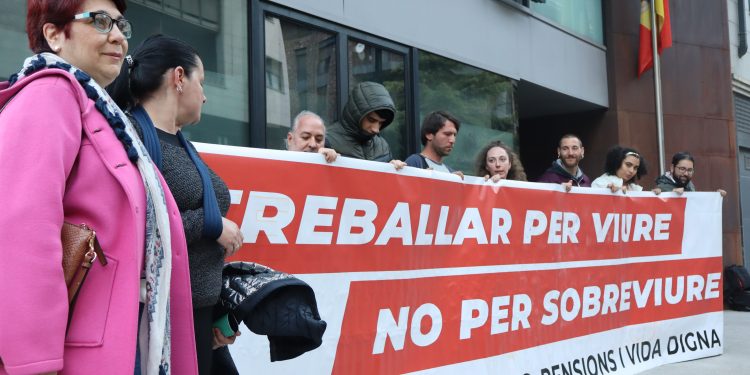 La portaveu del Sindicat de l'Habitatge, Rebeca Bonache, i altres membres del col·lectiu amb una pancarta després de la reunió amb la ministra d'Habitatge, Conxita Marsol. Foto: I. M. (ANA)