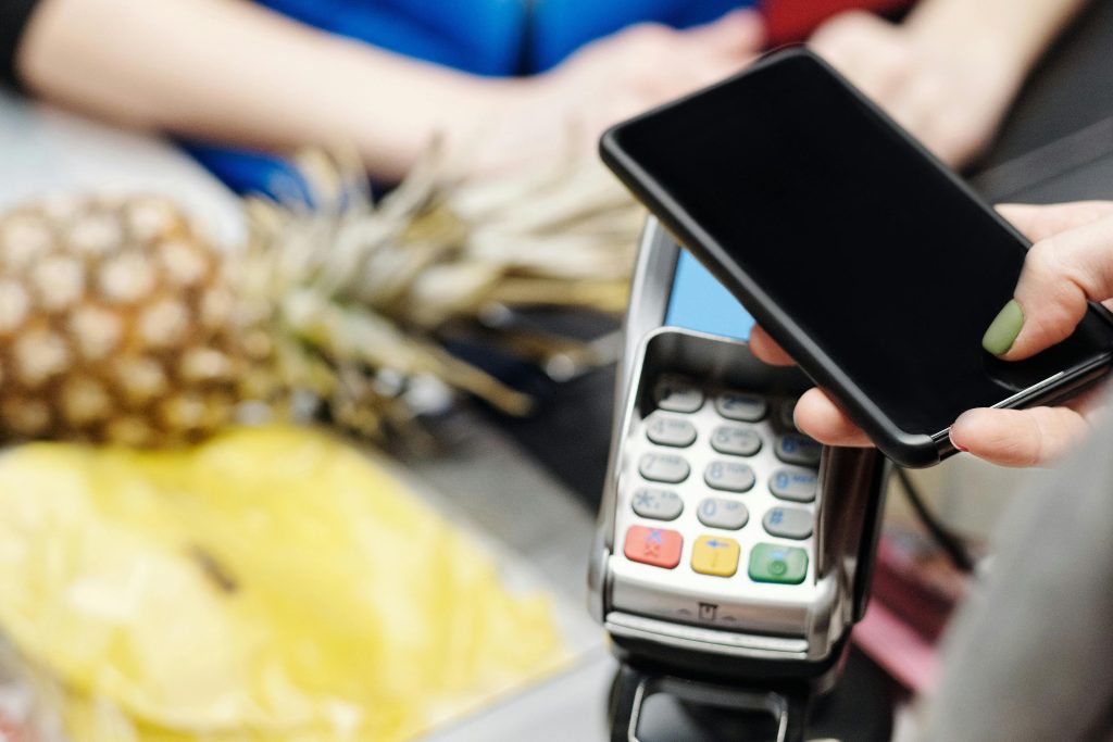 Una noia pagant una compra amb el seu telèfon mòbil. Foto: Pexels