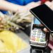 Una noia pagant una compra amb el seu telèfon mòbil. Foto: Pexels