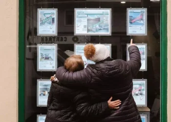 Dues dones miren anuncis en l'aparador d'una immobiliària / KT