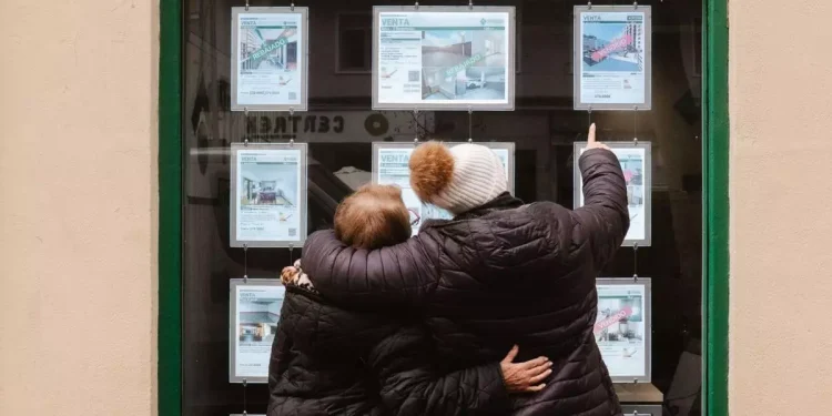 Dues dones miren anuncis en l'aparador d'una immobiliària / KT